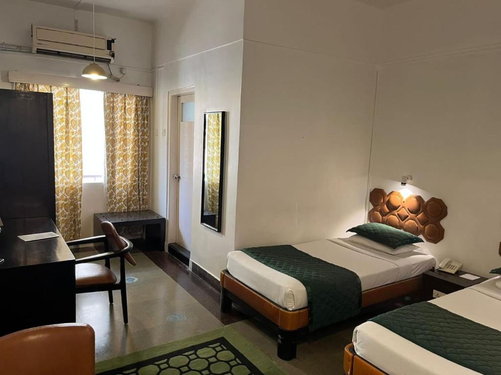 Postel nebo postele na pokoji v ubytování West End Hotel Opp Bombay Hospital