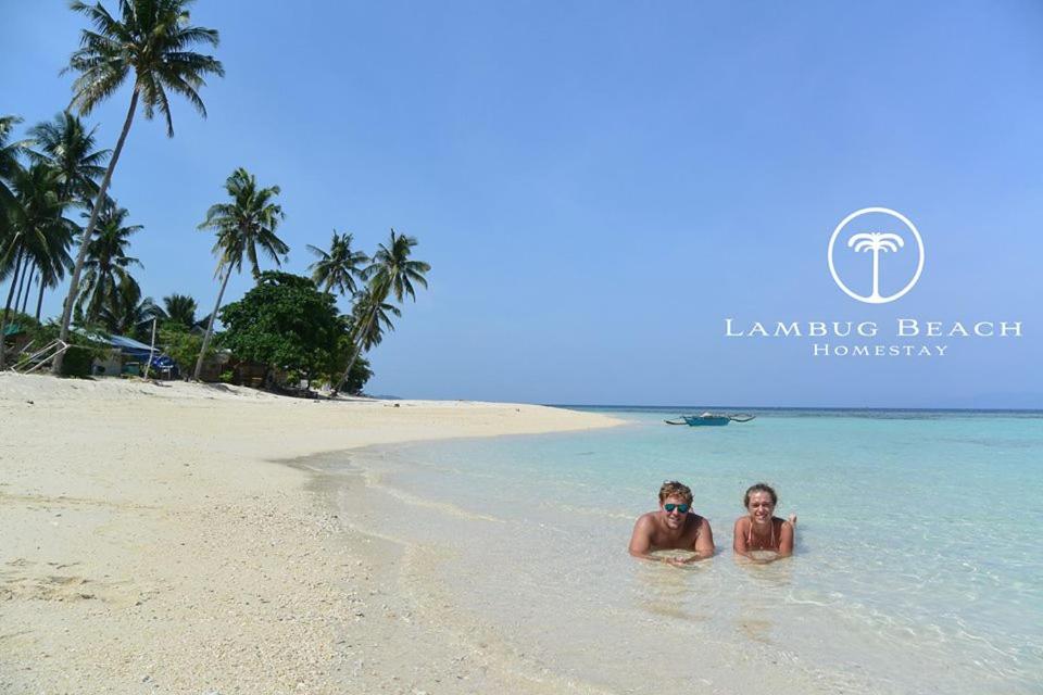 2 personnes dans l'eau sur une plage dans l'établissement Lambug Beach Homestay, à Lambug