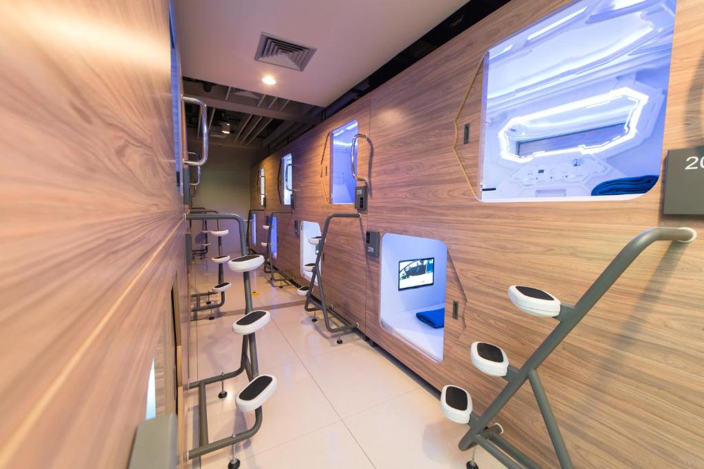 a hospital room with a row of stools at PassGo Digital Airport Hotel Bali in Kuta