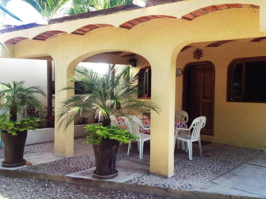 een huis met een patio met een tafel en stoelen bij Bungalow Casa de los Abuelos in Lo de Marcos