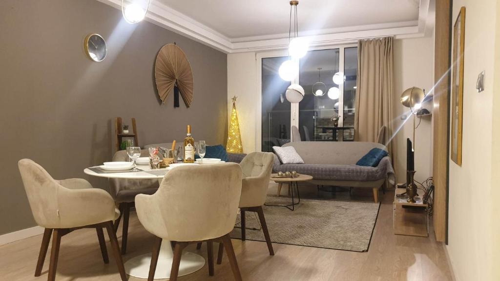 Temi's Apartments 2 في إسكوبية: غرفة طعام وغرفة معيشة مع طاولة وكراسي