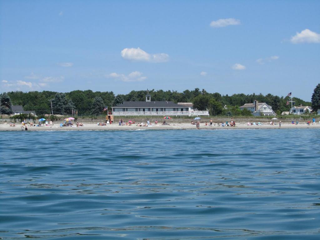 a group of people on a beach near the water at The Seaside Inn in Kennebunk Beach