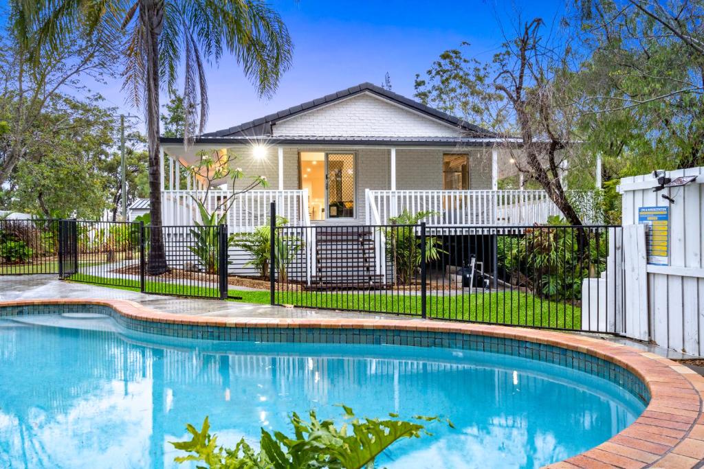 ein Haus mit einem Pool vor einem Haus in der Unterkunft 4 Bedroom Family Home with Pool - Uplands Drive - Q Stay in Gold Coast