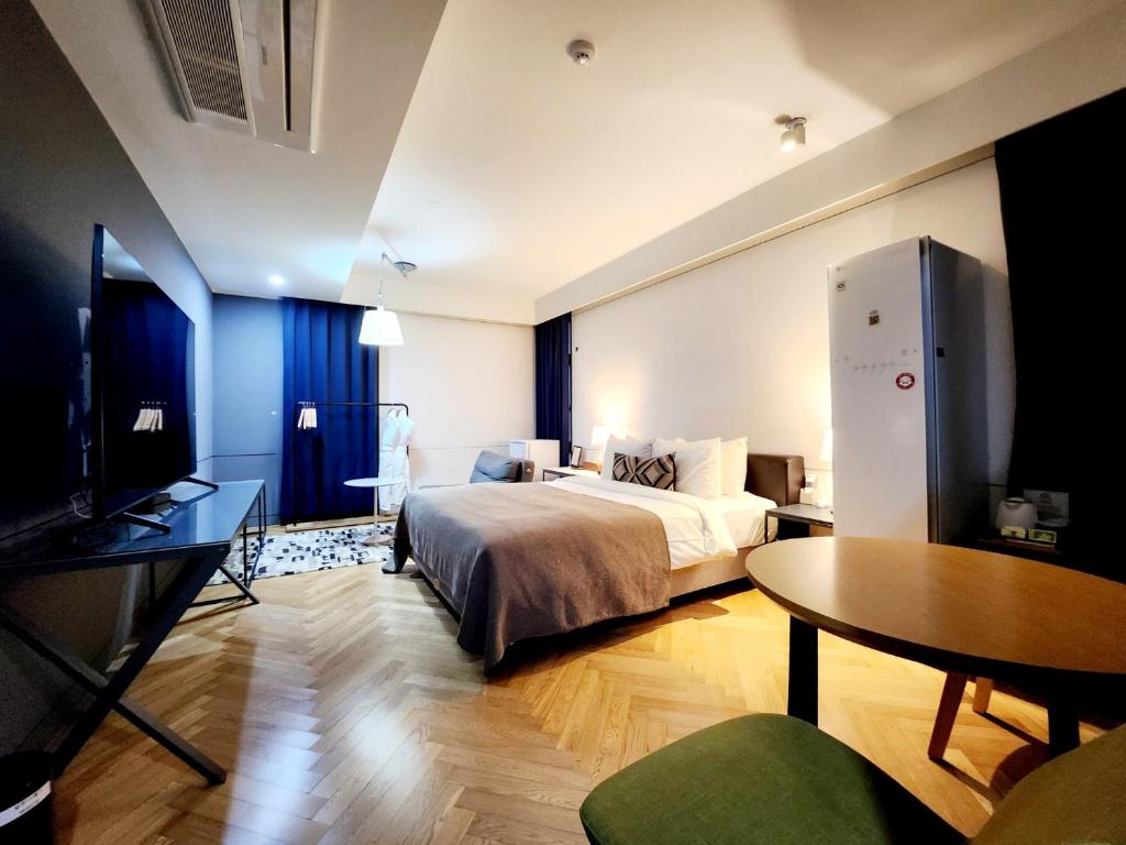 um quarto com uma cama, uma secretária e uma mesa em JS Boutique Hotel em Hwaseong