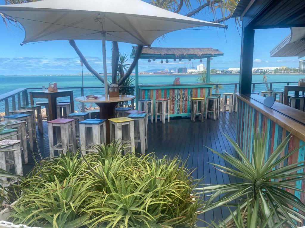 a restaurant with tables and chairs and an umbrella at Water Front Townsville in North Ward