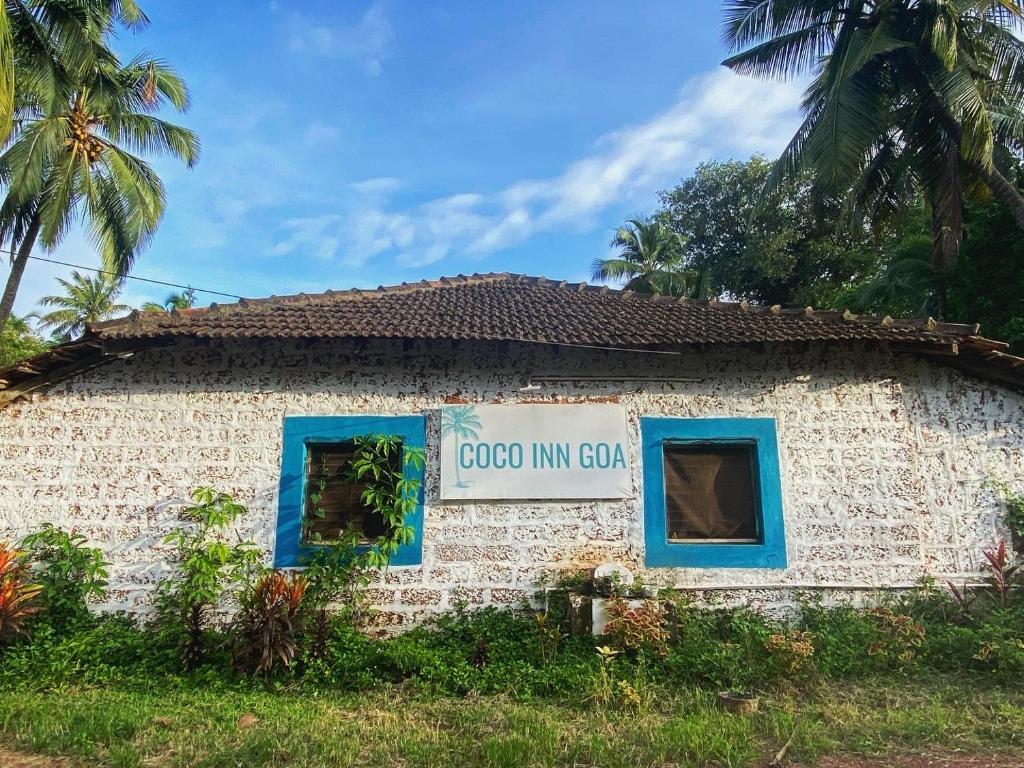 a building with a sign on the side of it at Coco inn Goa in Candolim