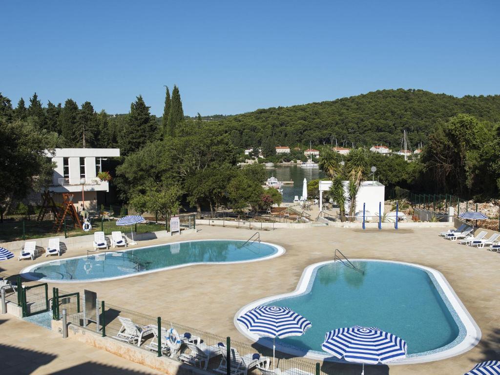 ein großer Pool mit Stühlen und Sonnenschirmen in der Unterkunft Apartments Aminess Port 9 Residence Korcula - CIN1000d-CYB in Korčula