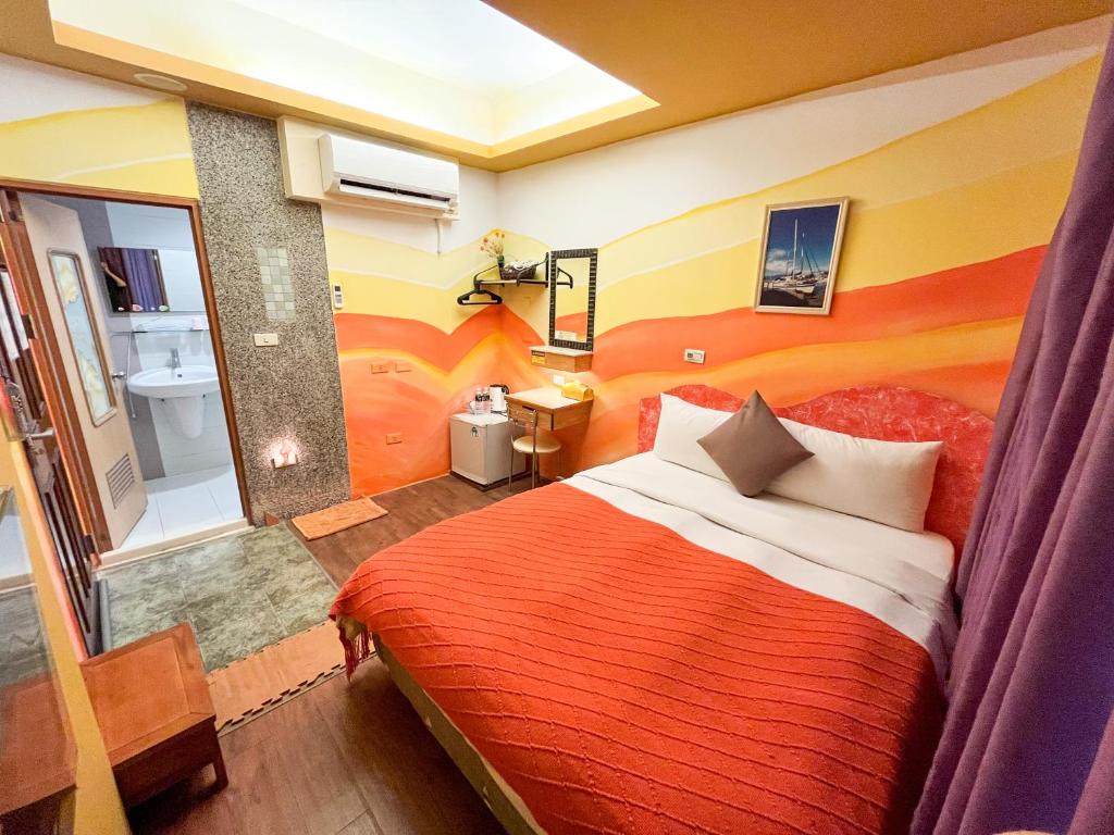 a hotel room with a bed and a bathroom at Tz Shin Resort Hostel in Kenting