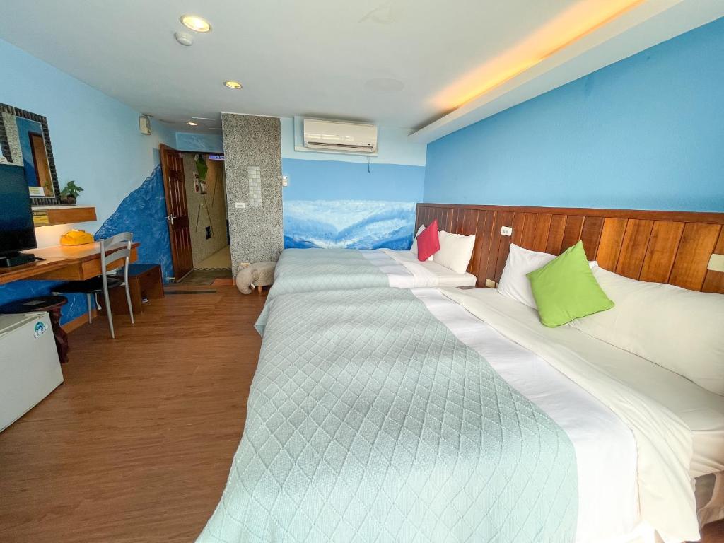 a large white bed in a room with blue walls at Tz Shin Resort Hostel in Kenting