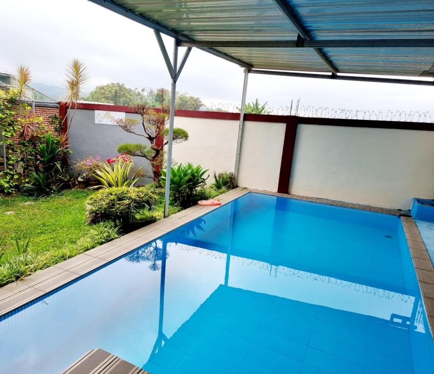 a swimming pool in a house with a roof at REESTY VILLA KOLAM RENANG VIEW GUNUNG dekat ALUN2 in Batu