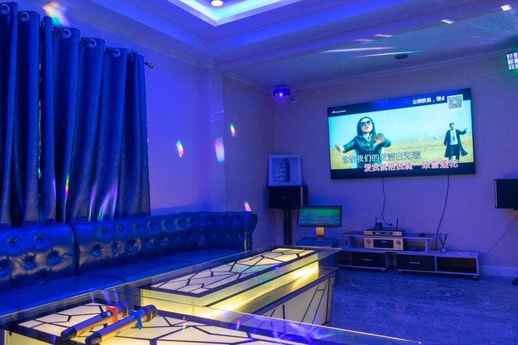 a living room with a couch and a flat screen tv at wonderland2 village KTV pool villa in Pattaya North