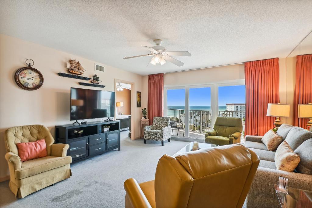 a living room with a television and a couch and chairs at SeaCrest 706 condo in Fort Walton Beach