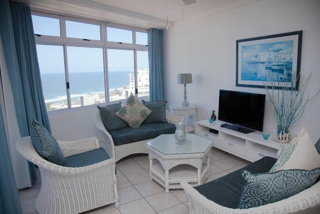 a living room with a couch and chairs and a television at Sealodge 75 Umhlanga Durban in Durban