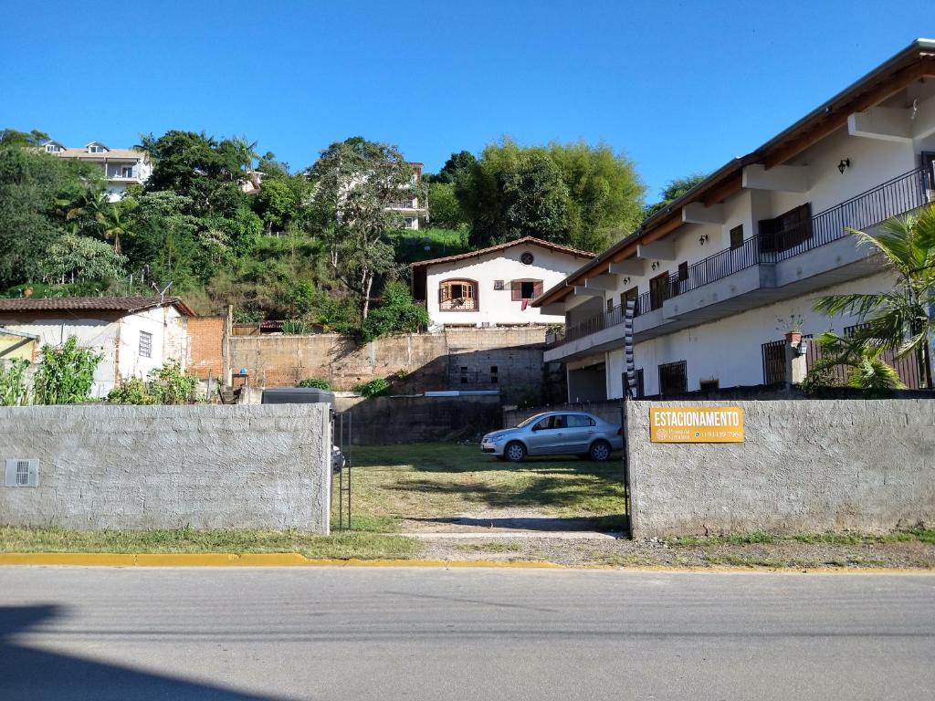une voiture garée devant un immeuble dans l'établissement POUSADA GIRASSOL, à Santo Antônio do Pinhal