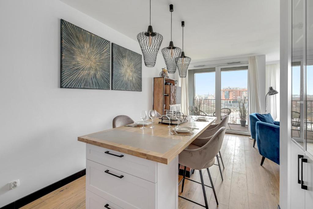 a kitchen and dining room with a table and chairs at Downtown Apartments Chlebova Riverside - Parking & Gym in Gdańsk