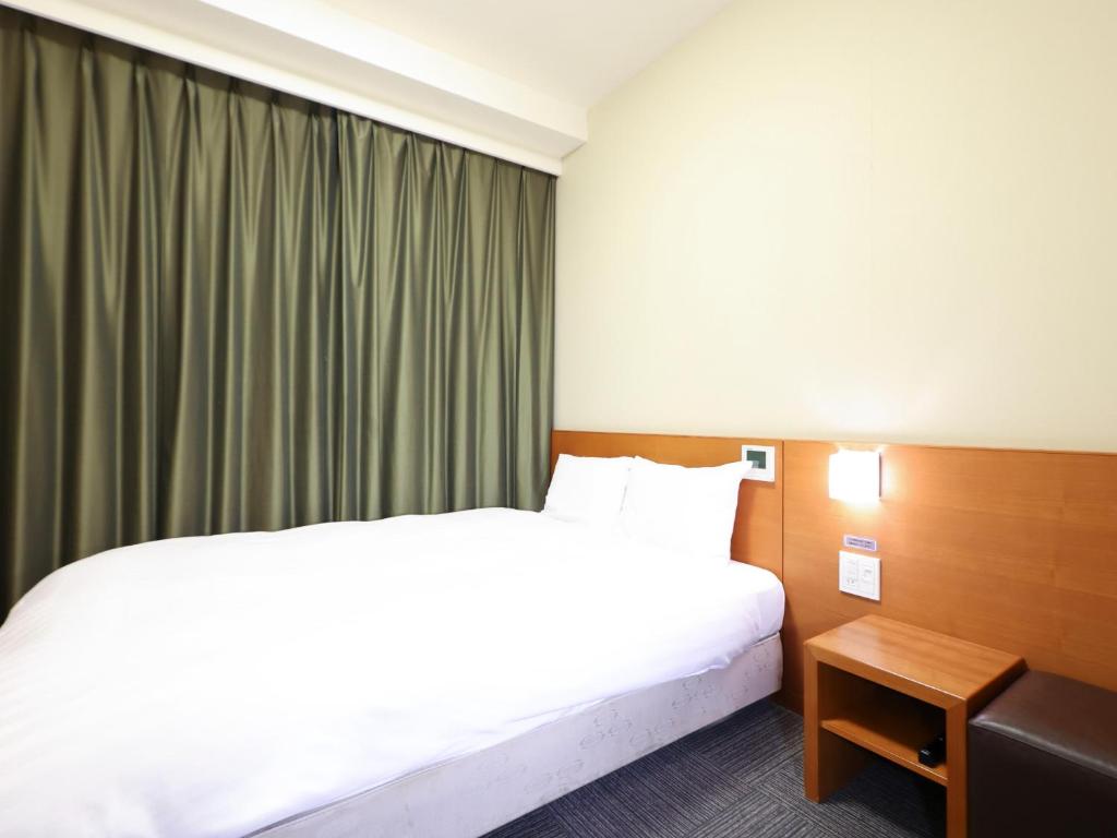 Postel nebo postele na pokoji v ubytování Dormy Inn Takasaki