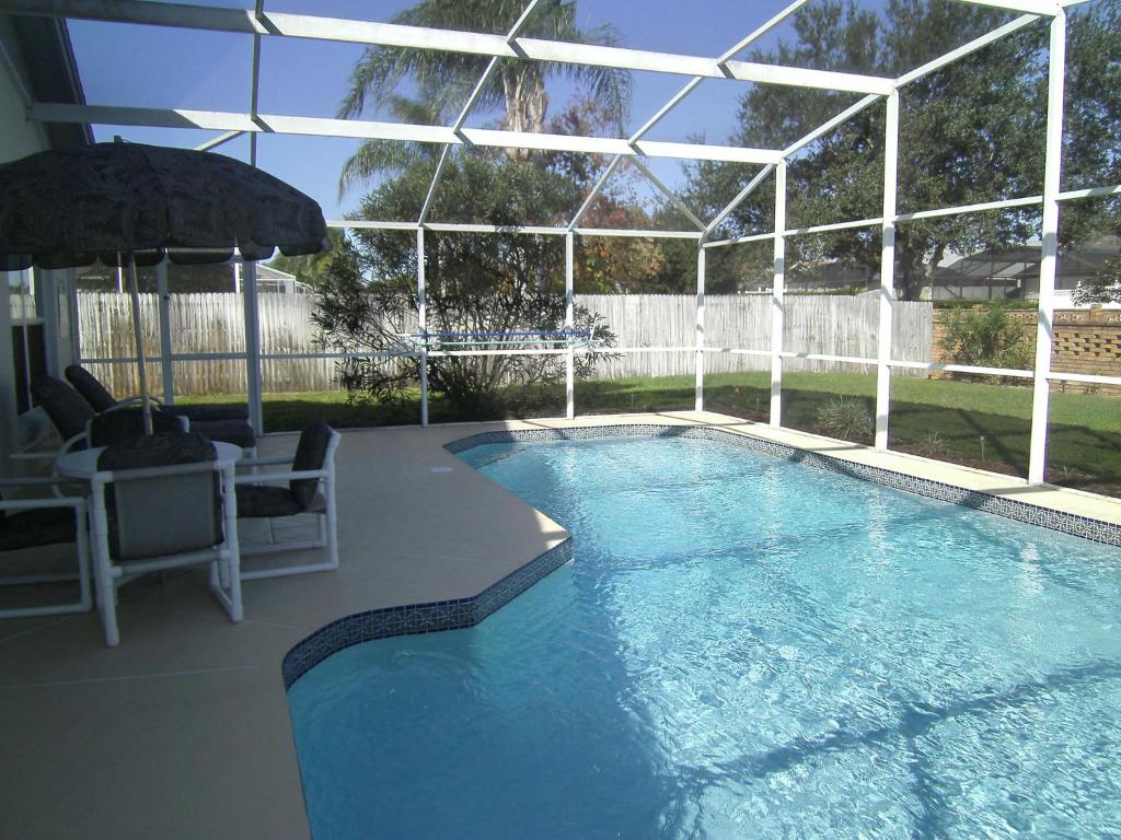a large swimming pool with a pavilion and an outdoor poolvisor at 4 Bedroom Value Plus Home with Private Pool in Orlando