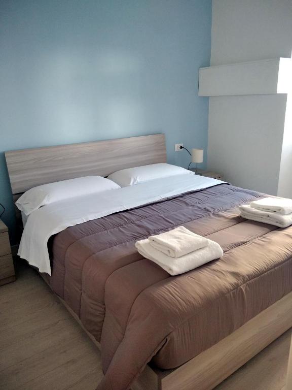 sypialnia z dużym łóżkiem z dwoma ręcznikami w obiekcie Chiarini22 Apartments w mieście Neapol