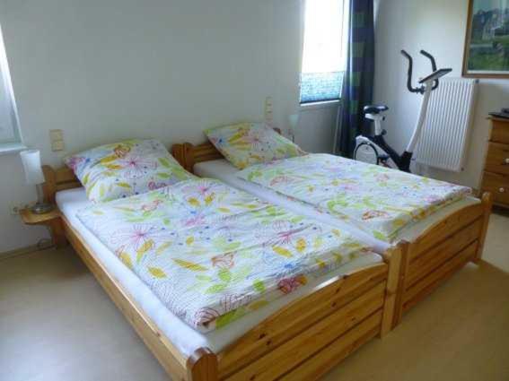 a bedroom with a wooden bed with flowers on it at Ferienwohnung Stoeterau in Erfde