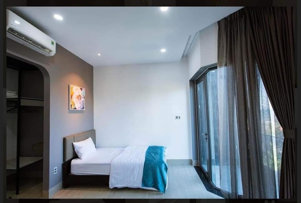 タムキーにあるCanh Tien Homestay Tam Thanh Beachのベッドルーム1室(ベッド1台、大きな窓付)