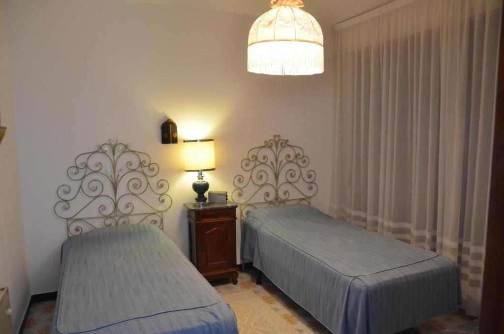 a bedroom with two beds and a lamp on a table at Rocce di Capo Mimosa - Cervo in Cervo