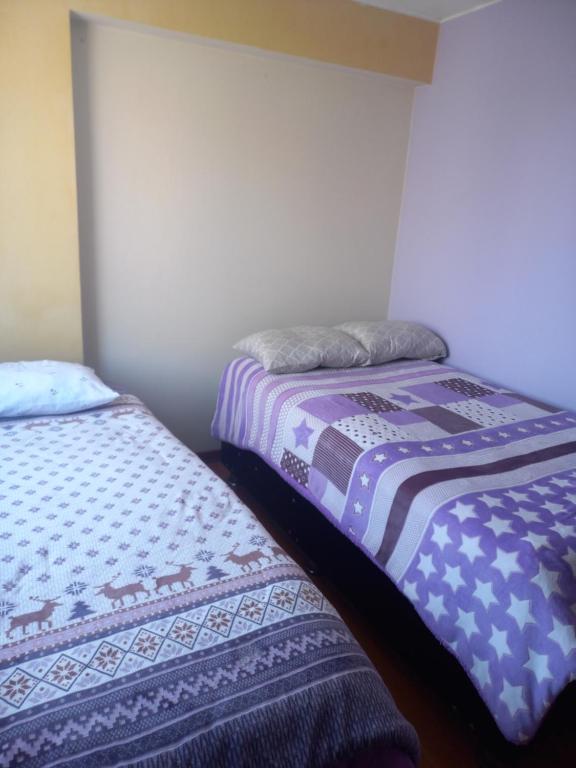 dos camas sentadas una al lado de la otra en una habitación en Apartamento frente a hermoso Parque, en Lima