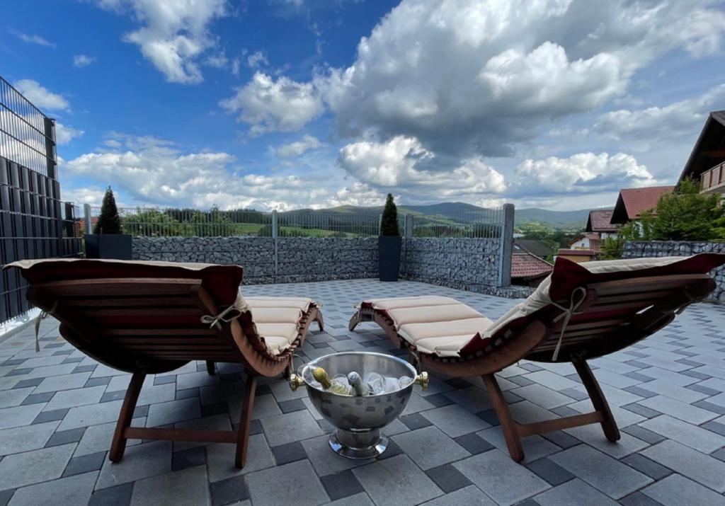 a patio with two chairs and a table on a patio at Black&White Luxus Appartement - Wilbergé Chalets in Gotteszell