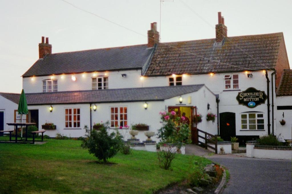 a white inn with lights on the front of it at Shoulder of Mutton in Foxton