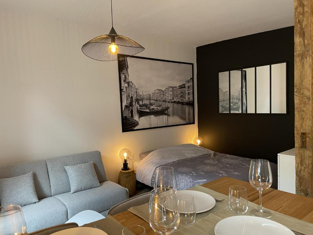 a living room with a bed and a table with wine glasses at Très Grand Studio - Terrasse in Strasbourg