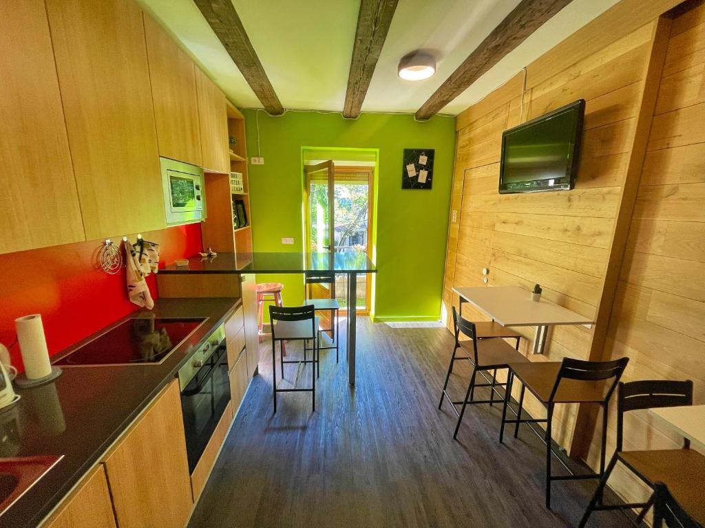 - une cuisine avec des murs verts, une table et des chaises dans l'établissement Das Hostel Rijeka, à Rijeka