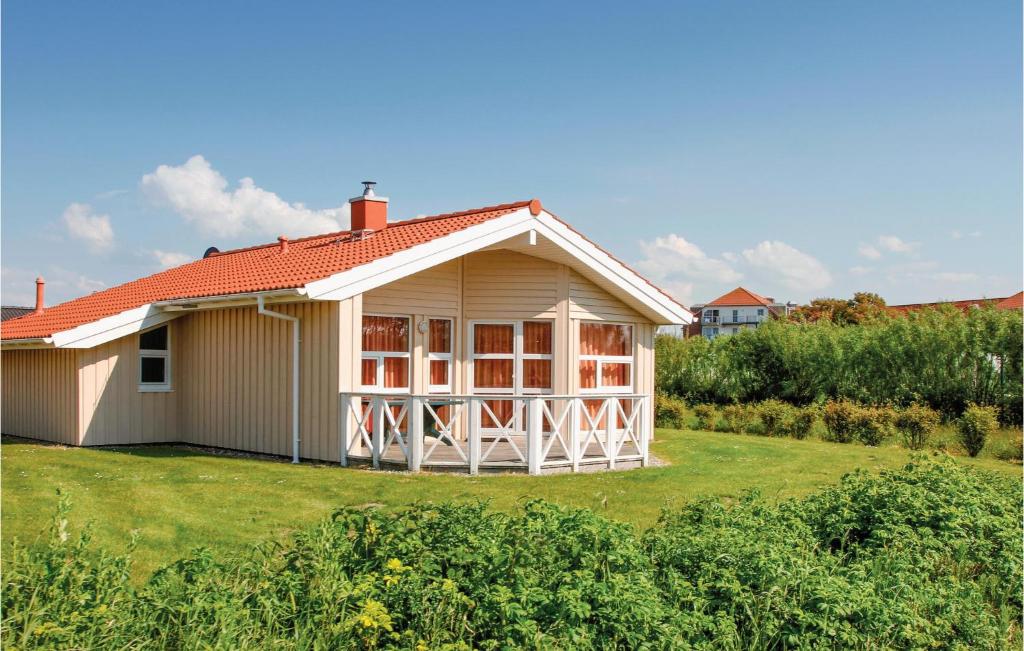 ein kleines weißes Haus mit orangefarbenem Dach in der Unterkunft Friedrichskoog-strandpark 4 in Friedrichskoog