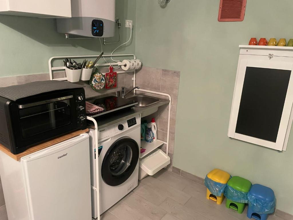una cucina con lavatrice e lavandino di Piccolo paradiso a Prata