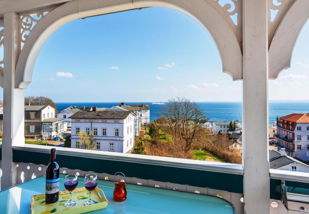 un balcón con 2 copas de vino y vistas al océano en Villa Bella Vista - Meerblick 4, en Sassnitz