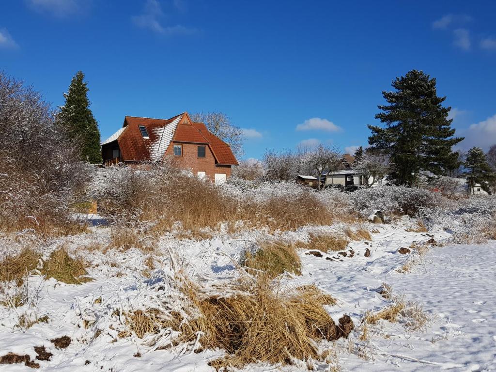 Ein Haus auf einem Feld mit Schnee darauf in der Unterkunft "Blick auf Vilm", Neuendorf in Putbus