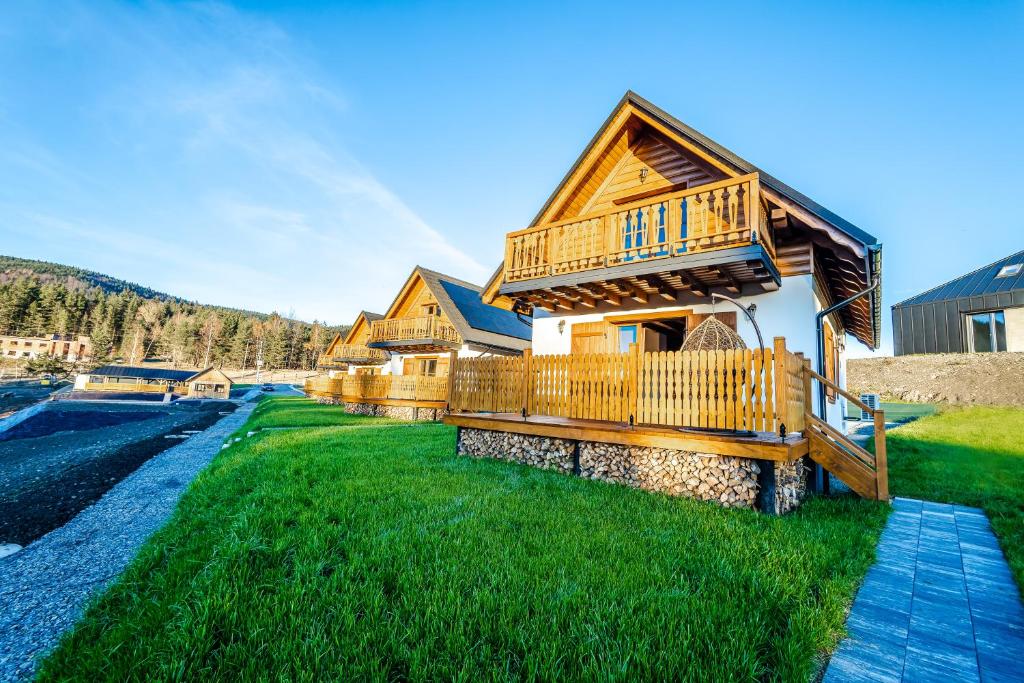 a log cabin with a balcony on a green lawn at Wierchy Beskidu in Dobra