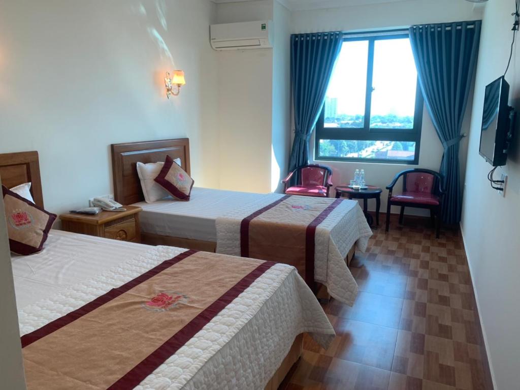 a hotel room with two beds and a window at Trường Thịnh Hotel in Vinh