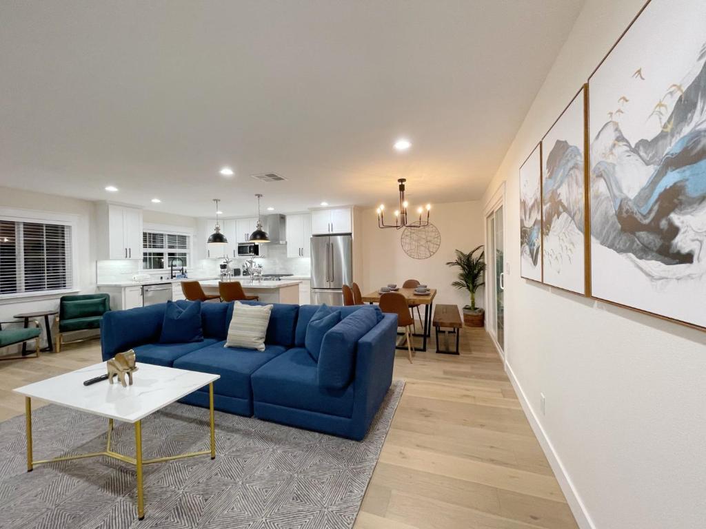 ein Wohnzimmer mit einem blauen Sofa und einem Tisch in der Unterkunft @ Marbella Lane – Contemporary Sophisticated Home in Sunnyvale