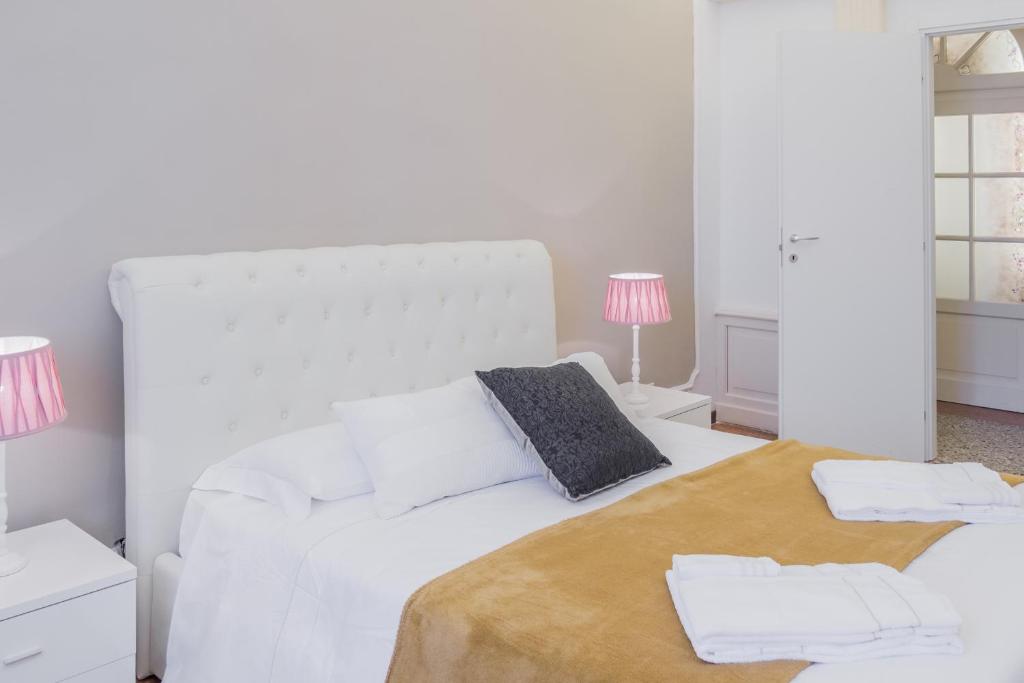 a white bedroom with a white bed with two pillows at Venice Dream Apartments in Venice