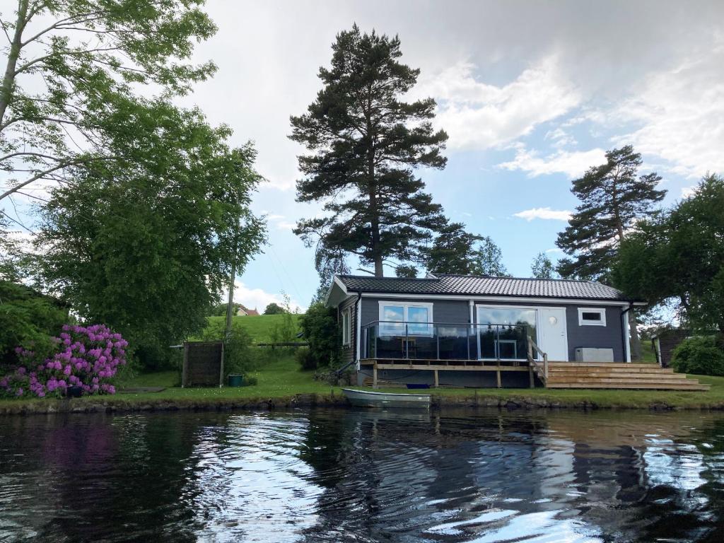 a tiny house on the side of a river at Lovely cottage in Bankeryd with a panoramic view of the lake in Bankeryd