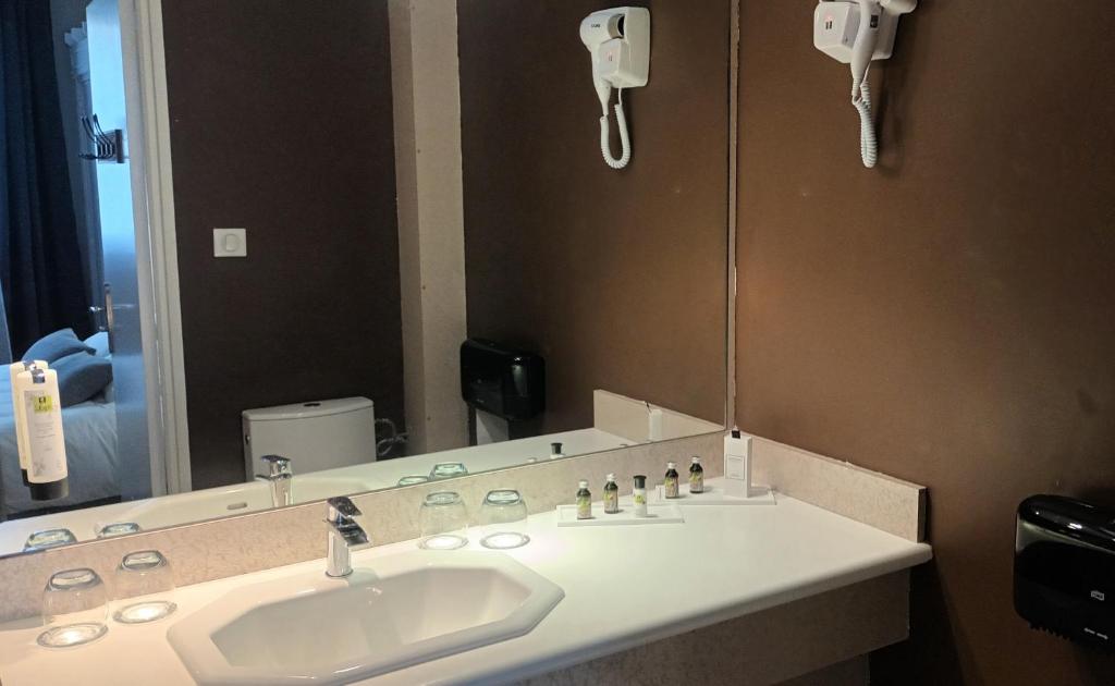 a bathroom with a sink and a large mirror at Logis Hôtel Spa la Poste in Vitry-le-François