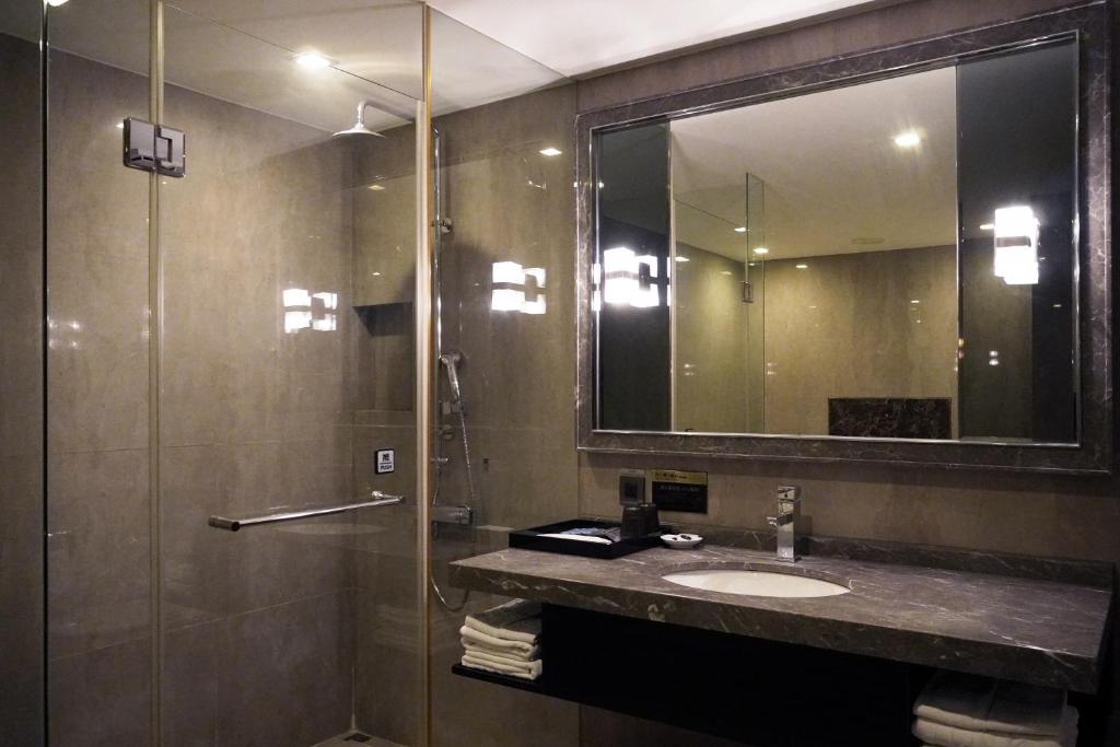a bathroom with a sink and a mirror at Talmud Hotel Kaohsiung LoveRiver in Kaohsiung