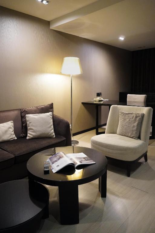a living room with a couch and a table at Talmud Hotel Kaohsiung LoveRiver in Kaohsiung
