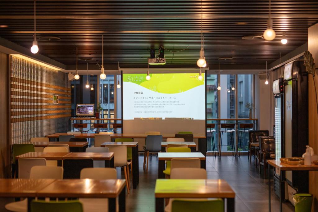 a restaurant with tables and chairs and a large screen at Chaiin Hotel - Dongmen in Taipei