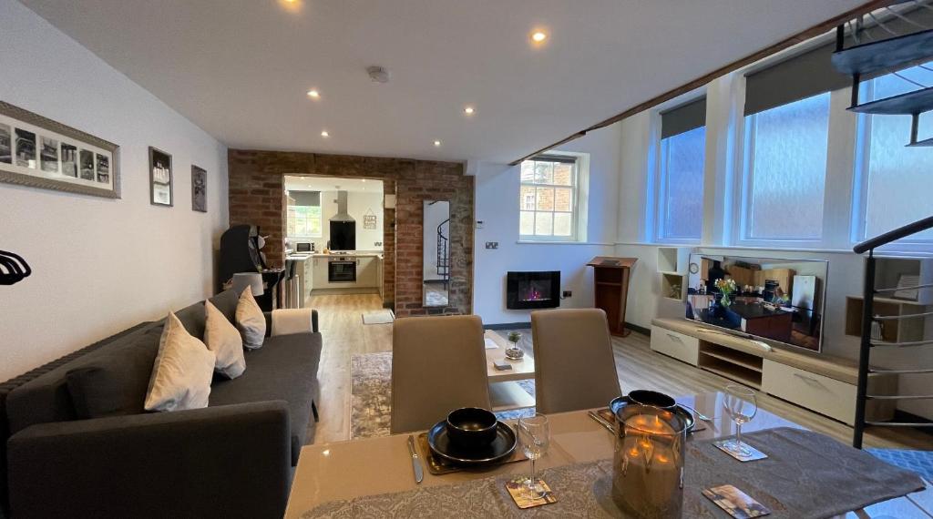 a living room with a couch and a dining room at Chapel row 1 in Wirksworth