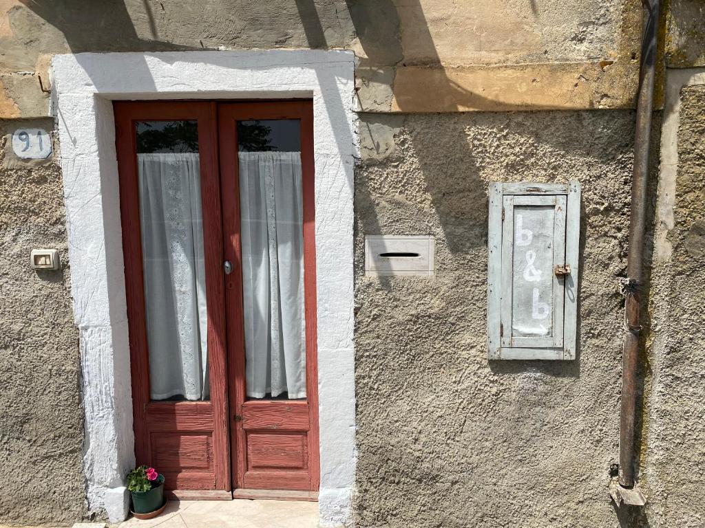 a red door and a window on a building at Casa al vecchio mulino in Sperlinga