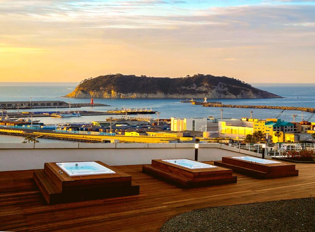 a balcony with a view of a harbor and the ocean at Hotel bridge Seogwipo in Seogwipo