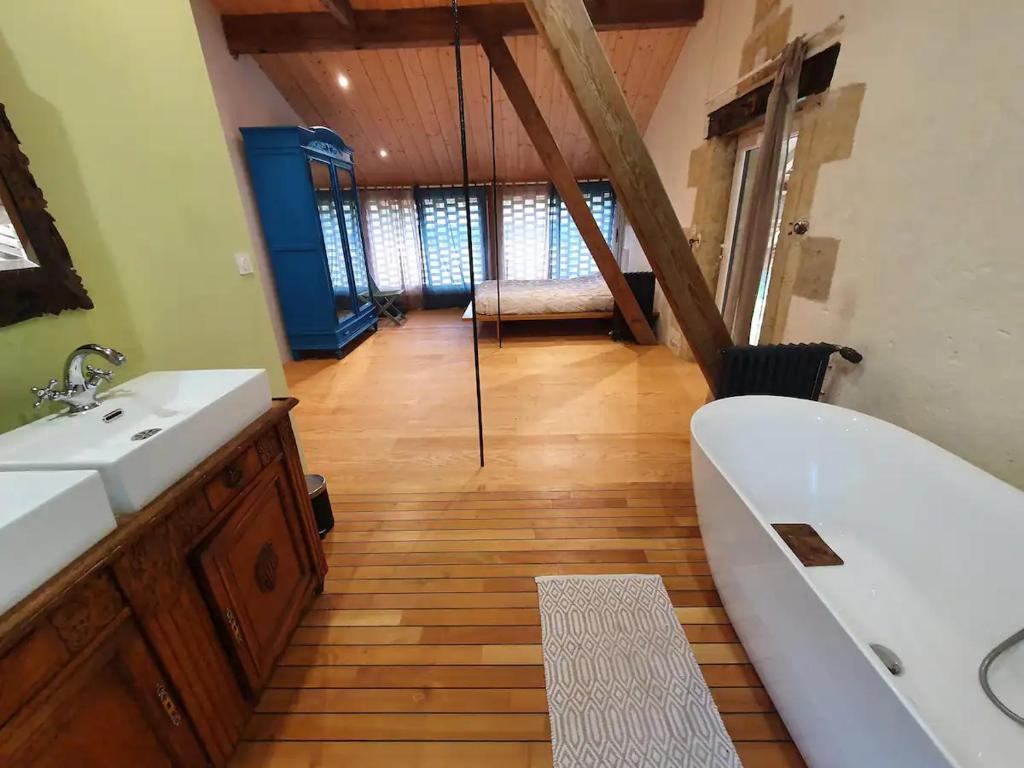 a bathroom with a tub and a sink and a bath tub at Chambre accès séparé, vignes, océan et Bordeaux in Moulis-en-Médoc