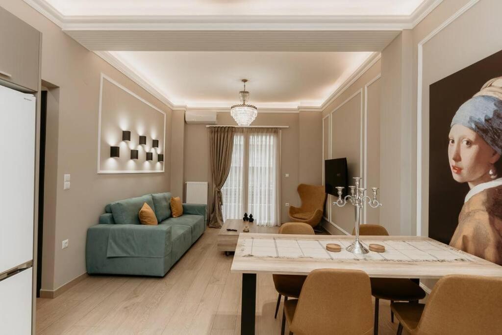 ein Wohnzimmer mit einem Tisch und einem Gemälde einer Frau in der Unterkunft Satus Finem Egnatia's Luxury Apartment in Thessaloniki