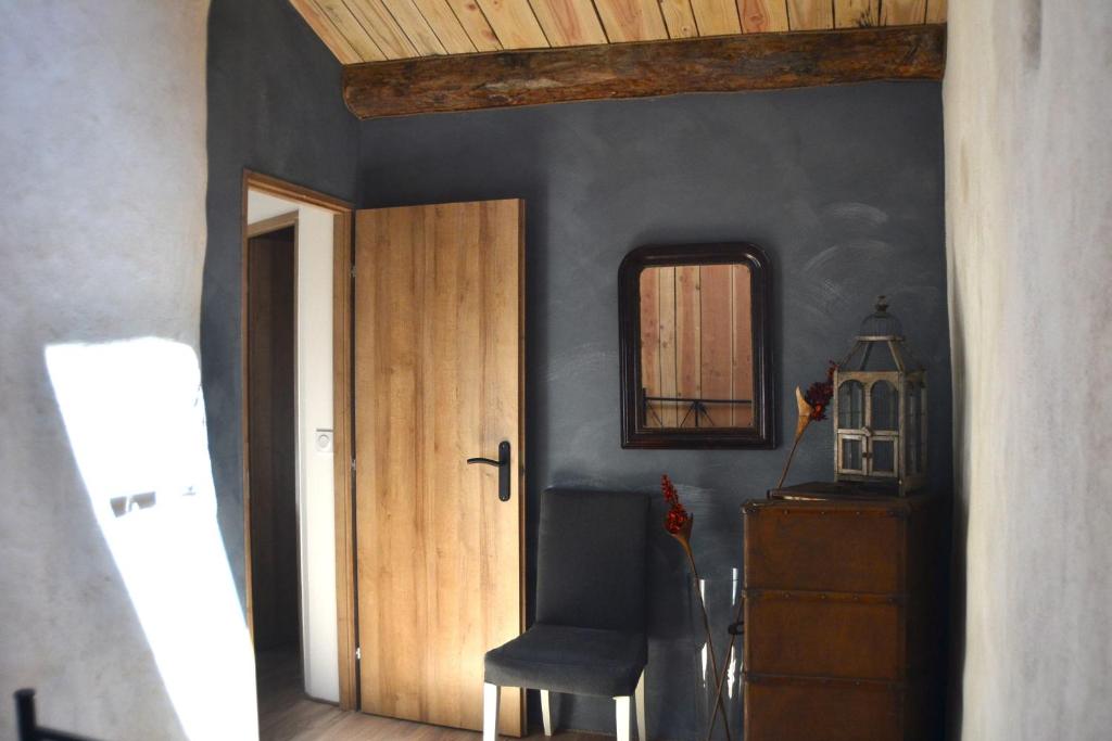 a hallway with a door and a chair and a mirror at Gîte &#39;An Kay Ou&#39; - Le Grand Barry in Pontaix