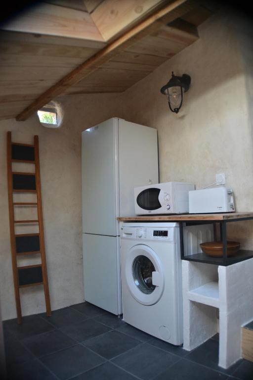 a kitchen with a refrigerator and a washing machine at Gîte &#39;An Kay Ou&#39; - Le Grand Barry in Pontaix